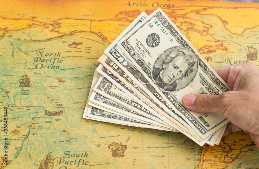Money for travel Hand holding US. dollar with vintage map