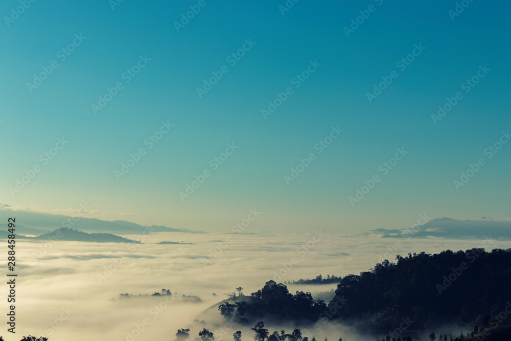 Beautiful  of mountain range landscape with winter blue sky from top view in majestic sunrise and fog.