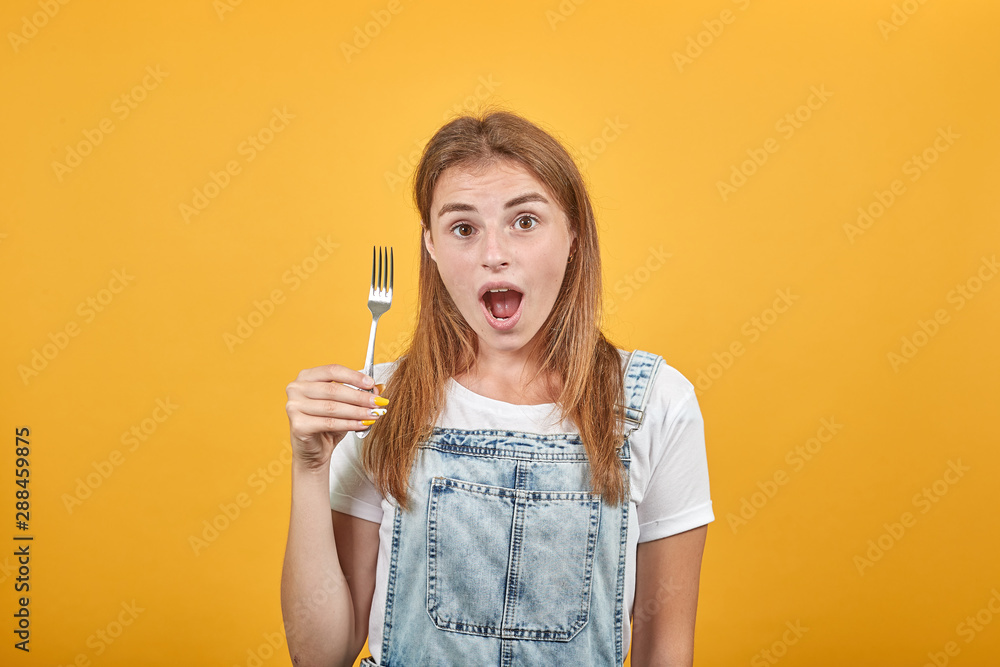 Young woman wearing white t-shirt, over orange background shows emotions Young woman wearing white t-shirt, over orange background shows emotions