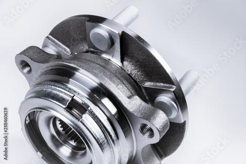 New Wheel hub assembly with bearing. This is part of the car suspension on a gray background with a gradient. The concept of new car parts photo