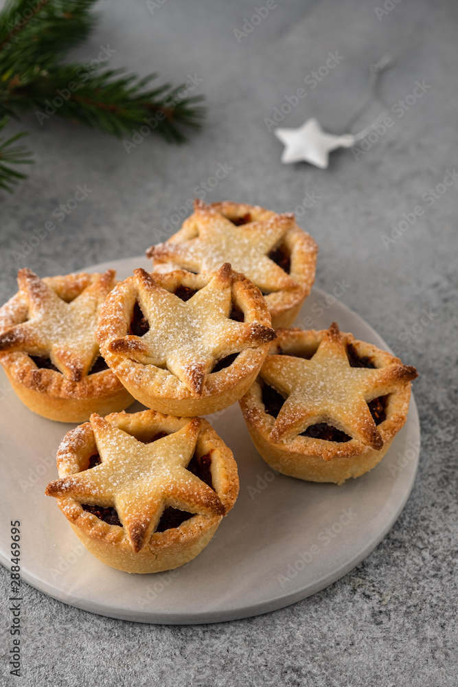 Delicious fruit mince tarts for Christmas dinner. Grey background, selective focus Delicious fruit mince tarts for Christmas dinner. Grey background, selective focus