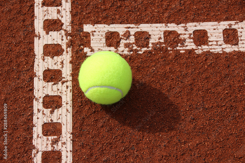 One tennis ball on tennis court with a line