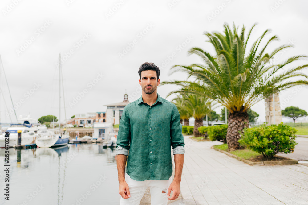 Attractive young man standing on the seafront