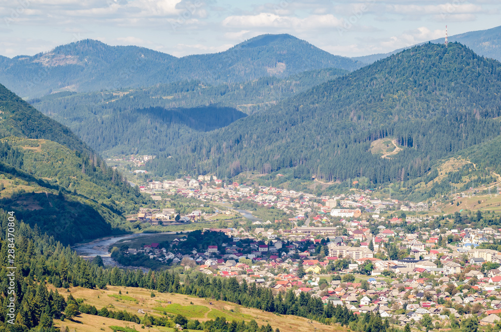 Fototapeta premium Ukraine Carpathians, a settlement in a valley of mountains, beautiful landscape aerial view