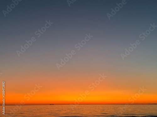 gradient evening sky, sea and ship silhoette © Iveta