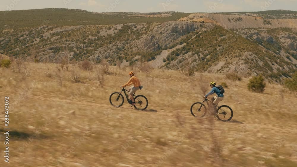 Tracking shot of two friends cycling Tracking shot of two friends cycling