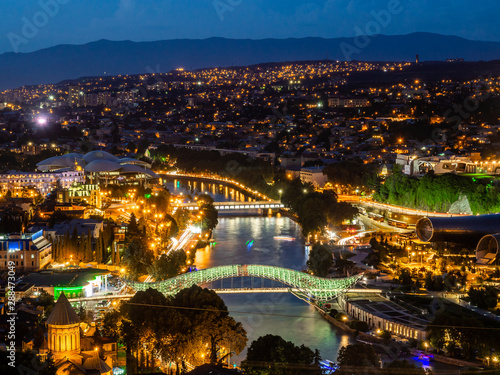 Beautiful cityscape with Bridge of Peace over Kura river in Tbilisi, Georgia, illuminated in the night.