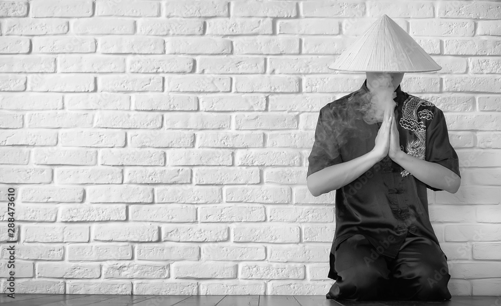 Asian novice on a white brick wall Asian novice on a white brick wall