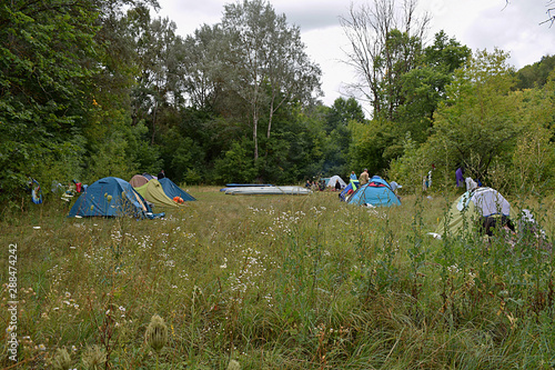 Camp tourists in a clearing on the banks of the river.