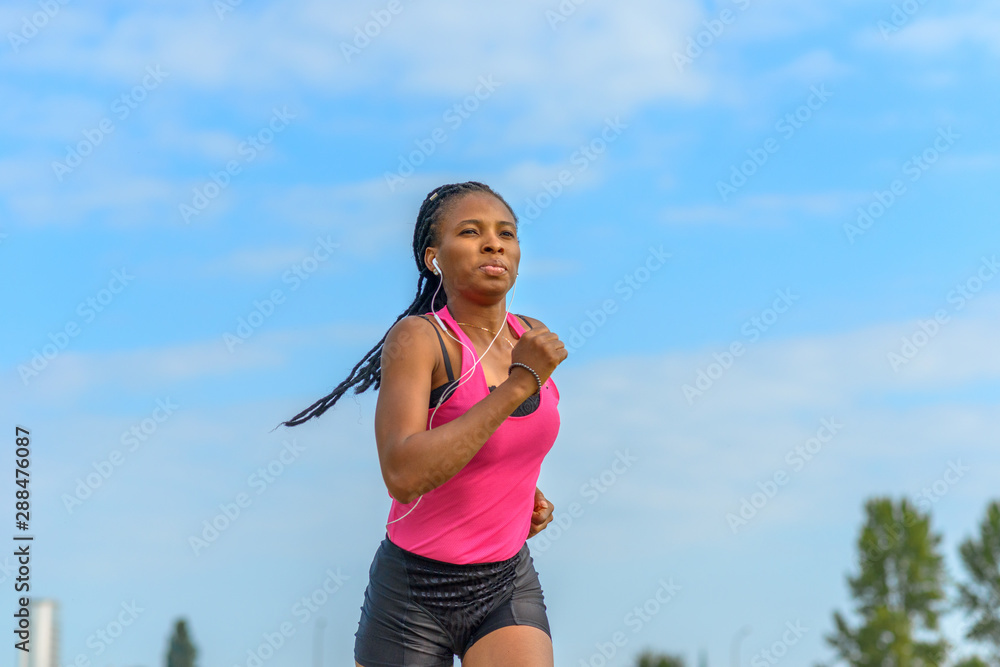 Fit determined young African woman jogging Fit determined young African woman jogging