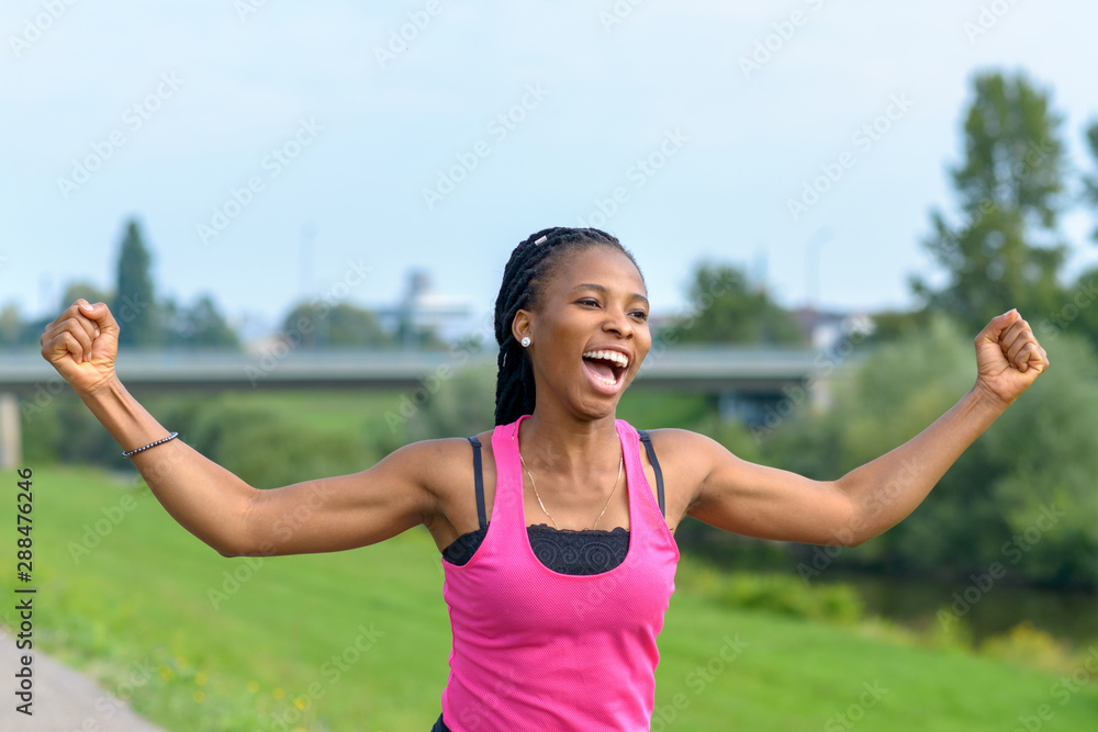 Vivacious young African woman cheering as she runs Vivacious young African woman cheering as she runs