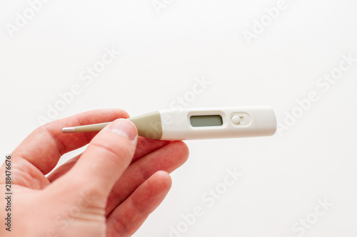 digital thermometer in hand on a white background isolated