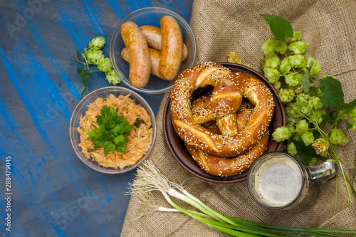 Traditional beer food from pretzel, fried sausages, cabbage, onions. Oktoberfest menu.