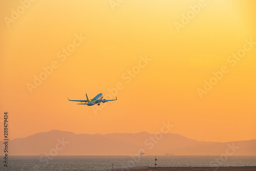 夕焼け空へ飛び立つ旅客機