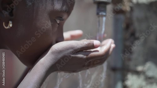Portrait Close up of African Black Child Girl Drinking Fresh Water