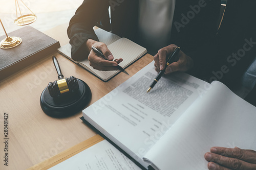 Judge gavel with Justice lawyers having team meeting at law firm background. Concepts of Law and Legal services.