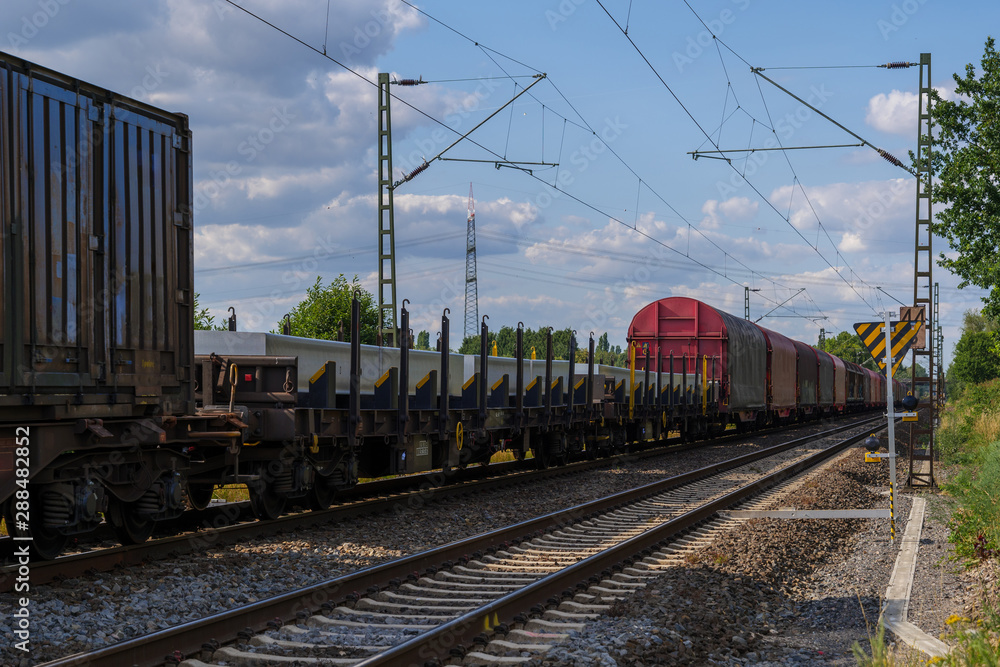 Outdoor sunny view of container train or railway freight transportation service, on the countryside in Germany. 