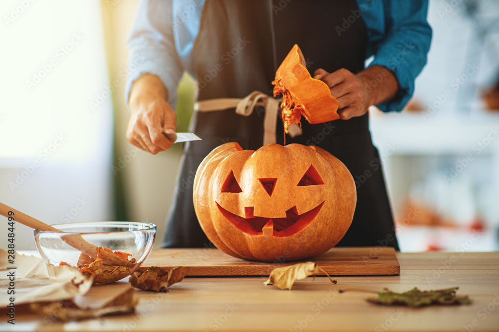 hands of  man cutting pumpkin to halloween. - obrazy, fototapety, plakaty 