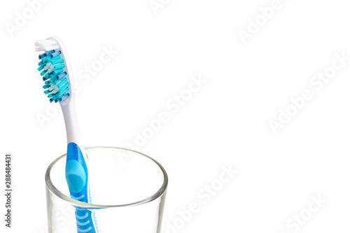 Colorful toothbrush in a glass. Oral hygiene concept. Isolated background. Copy space in the right.