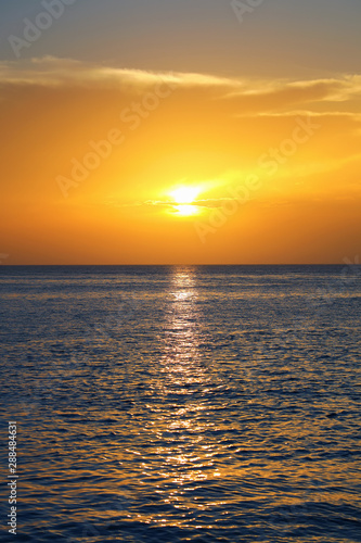 Colorful empty seascape with shiny sea over cloudy sky and sun during sunset in Cozumel, Mexico © jokerpro