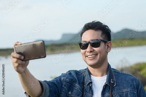 Asian tourist taking photo by his smart phone, lifestyle concept.
