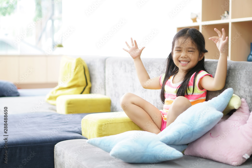 Asian child cute or kid girl smiling white teeth and happy cheerful sit on relax sofa with colorful resting pillow at home or nursery and kindergarten school with thinking for new idea at fun dental Asian child cute or kid girl smiling white teeth and happy cheerful sit on relax sofa with colorful resting pillow at home or nursery and kindergarten school with thinking for new idea at fun dental