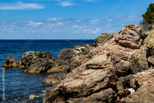 View on the coast at bay Cala Tuent on balearic island Mallorca, Spain on a sunny day with clear blue water and rocky coastline © Reiner