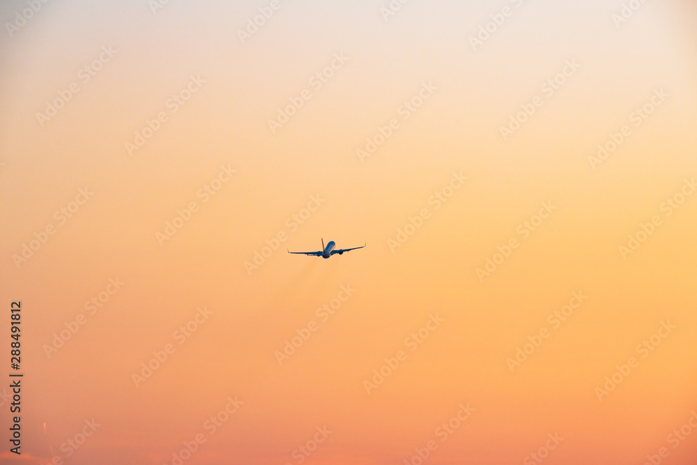 夕焼け空へ飛び立つ旅客機