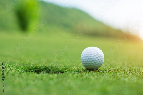 Golf ball on green grass ready to be struck at golf club