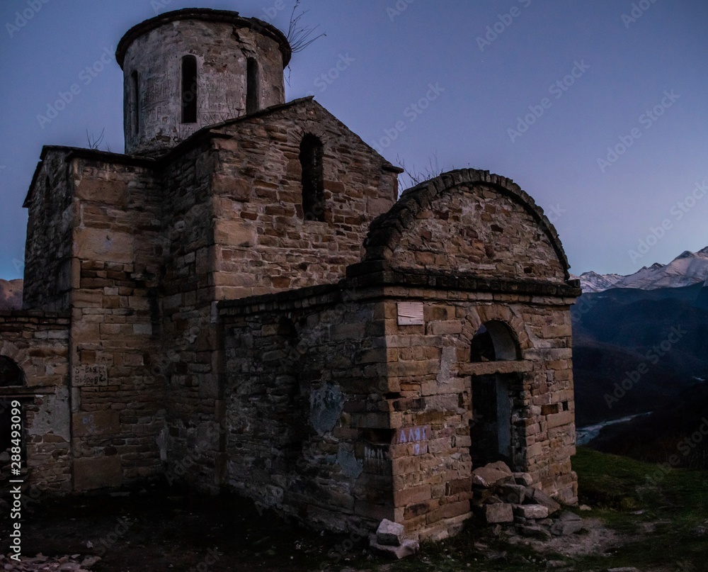 old abandoned Senty church in front of Caucasus mountain range in Teberda, Russia