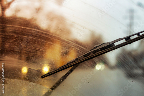 Windshield wipers from inside of car, season rain, front and background blurred with bokeh effect photo