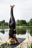 Kobieta uprawiająca jogę i medytację na świeżym powietrzu. Asana nad jeziorem. Instruktor jogi. 