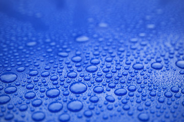 Closeup blue car paint surface with hydrophobic ceramic coating