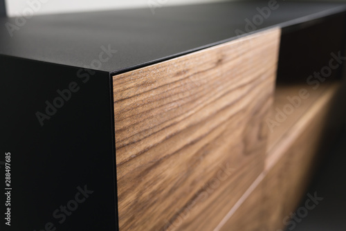 Closeup details of modern tv stand made from walnut and powder coated steed photo