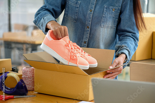 Online sellers are packing shoes in boxes to deliver to customers.