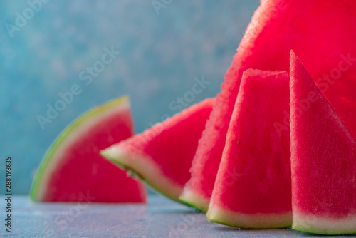 Close up shot of sweet spanish watermelon just cutted on blue background. Selective focus