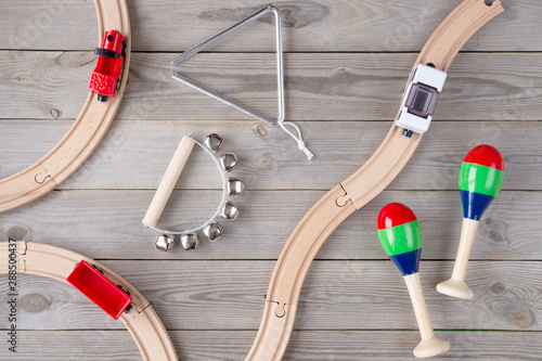 Toy train and wooden rails on wooden background. Top view. Copy space