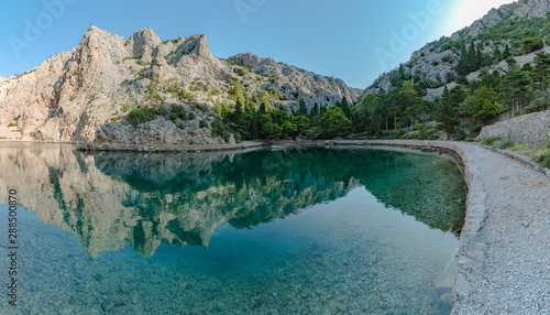 Reflection of the mountains in the water of the Zavratnica canyon near the village of Jablanac, Croatia