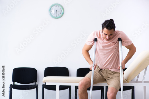Young injured man waiting for his turn in hospital hall
