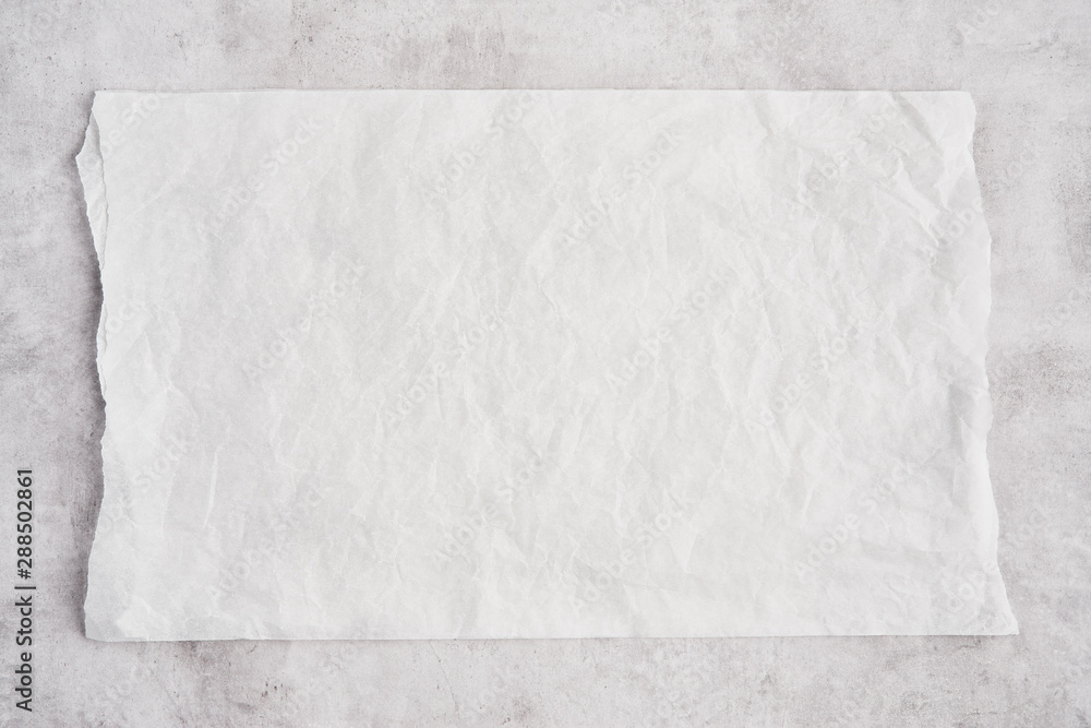 Crumpled piece of white parchment or baking paper on grey concrete background. Top view. Copy space for text and design element. - obrazy, fototapety, plakaty 