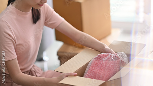 Cropped shot online small business owner packing drop product on box. photo