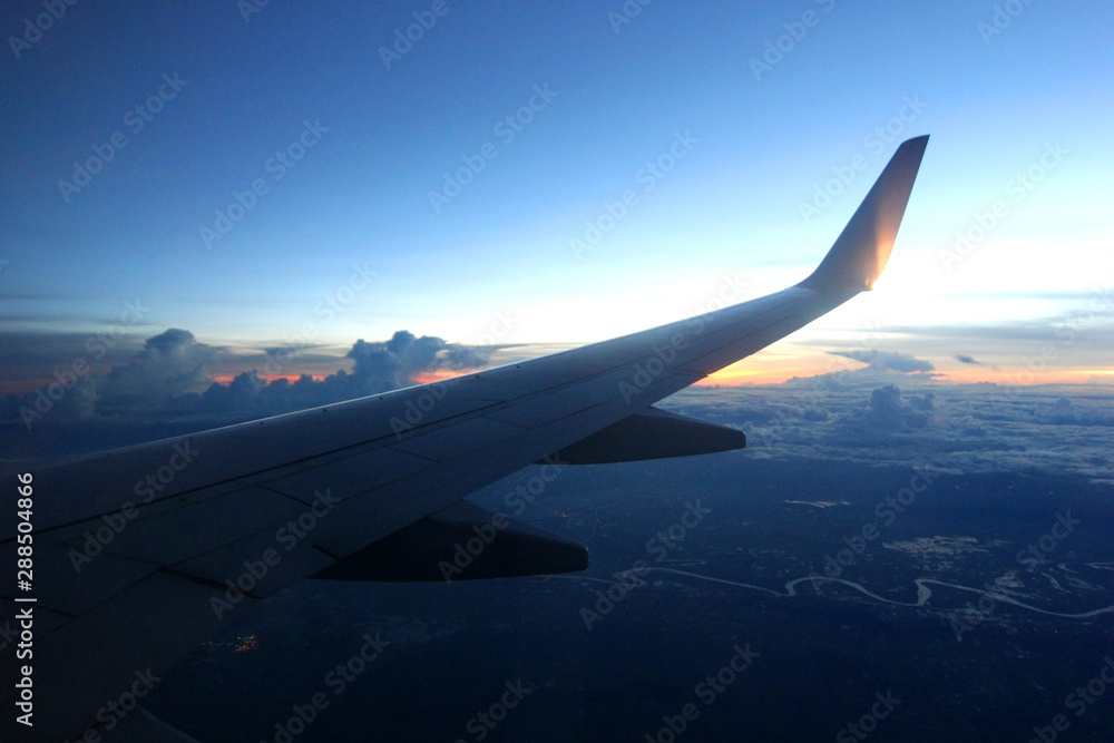 Obraz premium aircraft wing flying over beautiful clouds