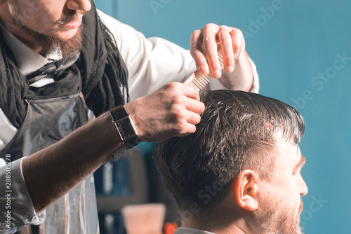 Hairdresser combing the hair of a man. Preparing for a haircut.