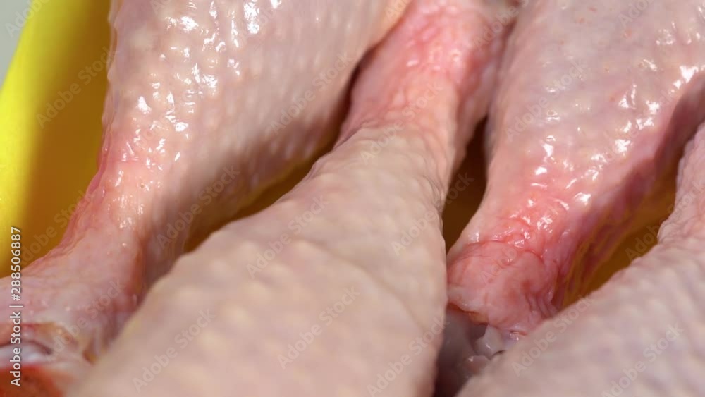 Closeup view of fresh raw uncooked chicken legs laying in plastic container. Closeup view of fresh raw uncooked chicken legs laying in plastic container.