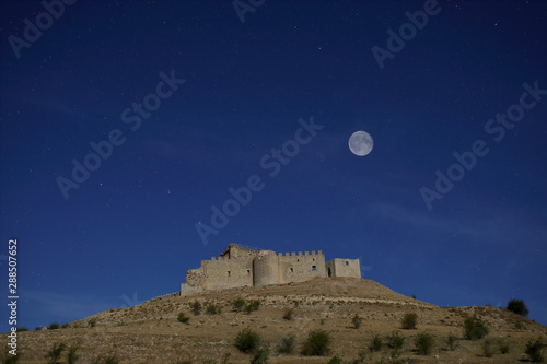 Night photograph with full moon and starry sky of the castle of Galve del Sorbe, XV century (Guadalajara, Spain)