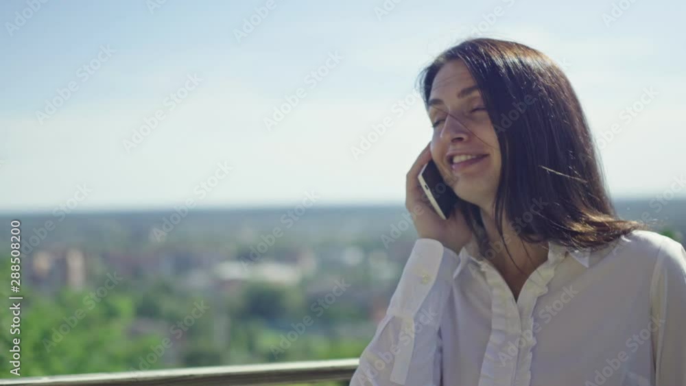 sunny day, beautiful brunette talking on the phone on the horizon sunny day, beautiful brunette talking on the phone on the horizon