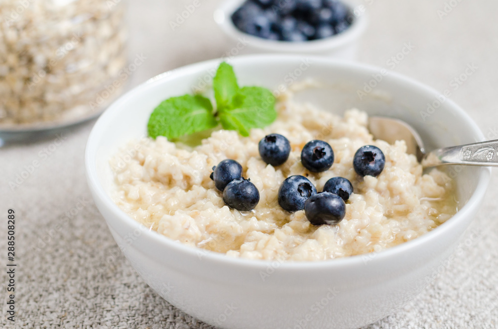 Healthy breakfast. porridge in a bowl with honey and berries and tea. Close-up Healthy breakfast. porridge in a bowl with honey and berries and tea. Close-up
