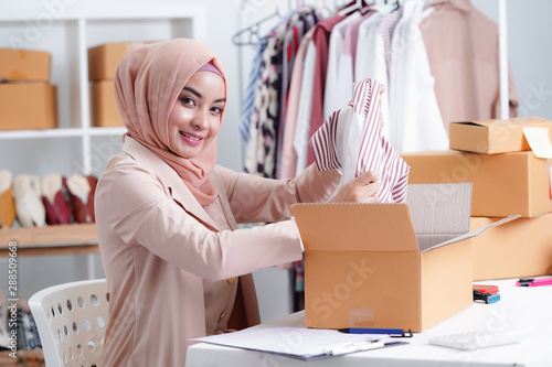 Muslim Business owner woman working online shopping prepare product packaging process at the office, young entrepreneur concept.