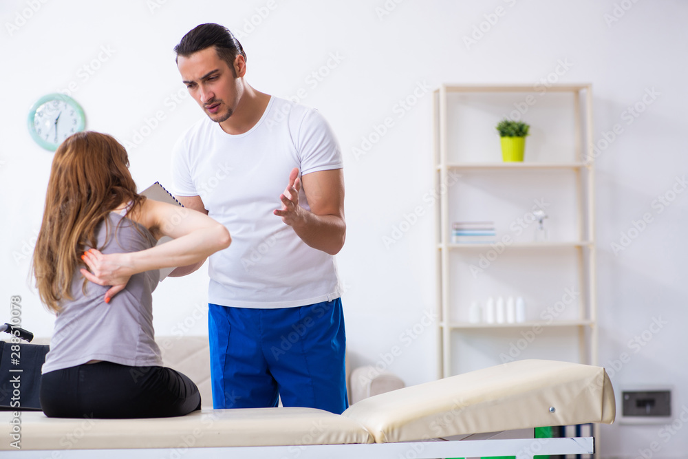 Obraz premium Young woman visiting male doctor physiotherapist