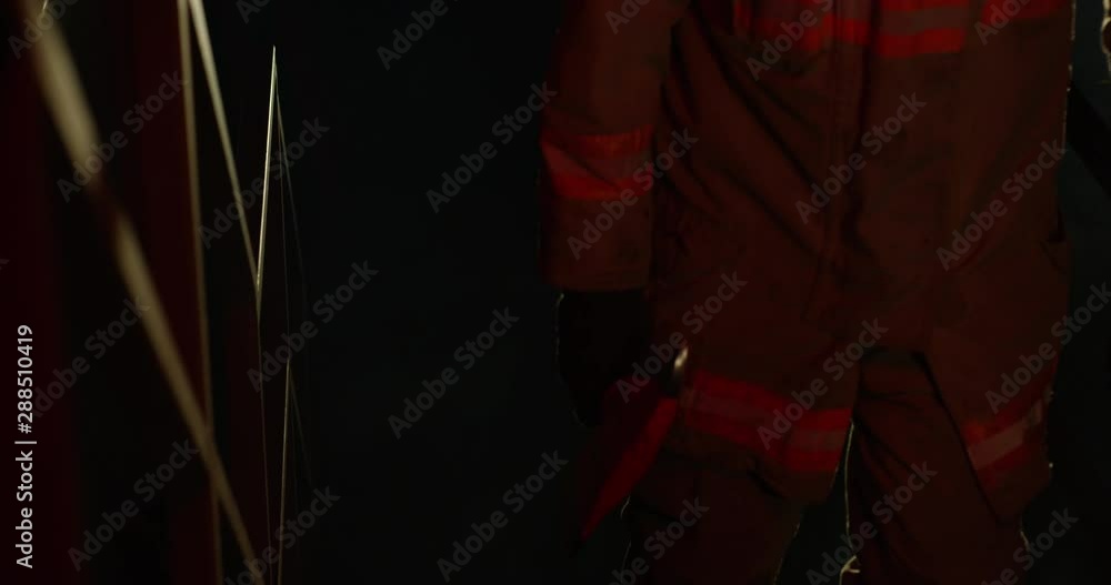 Fire fighter walking up stair case in industrial building - tilt down shot - lens flare Fire fighter walking up stair case in industrial building - tilt down shot - lens flare